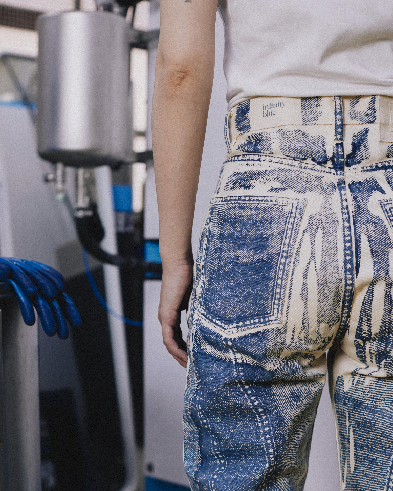 Person wearing blue jeans in a workshop setting
