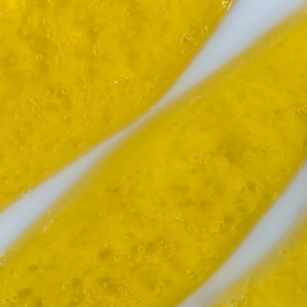 Close-up of a yellow gel liquid with visible bubbles, indicating a gel texture 