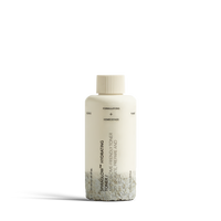 Dulcie Spiraglow Hydrating Toner 100mL bottle shown in a decomposed state to illustrate material breakdown